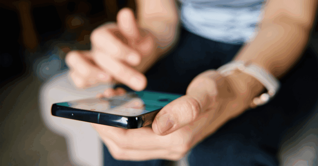 A close up of a phone in a woman's hands as she scrolls social media.